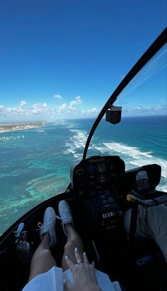 a person is sitting in an airplane flying over the ocean