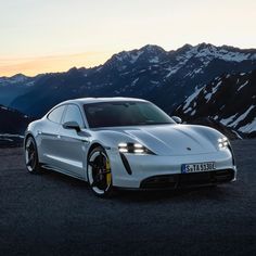 a white sports car parked on top of a mountain