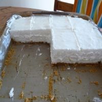 a cake sitting on top of a pan covered in frosting next to a chair