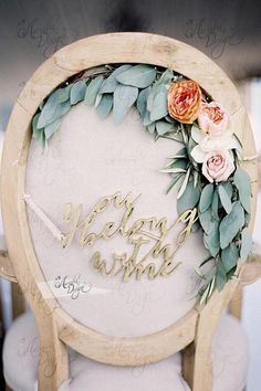 a wooden chair with a floral wreath on it that says,'we belong to wine '