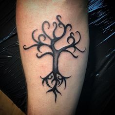 a black and white tree tattoo on the leg