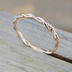 a close up view of a wedding ring on a wooden surface