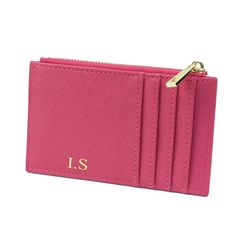 a pink card case with gold initials on it