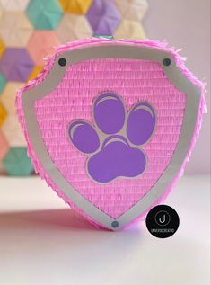 a pink basket with a purple paw print on the front and silver trim around it