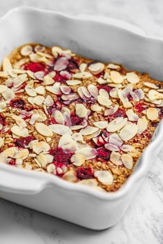 a white dish filled with oatmeal and raspberry baked in it