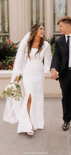 a bride and groom holding hands in front of a building