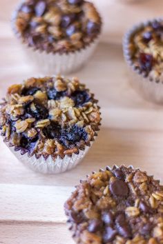 twelve muffins with blueberries and granola toppings arranged on a wooden surface