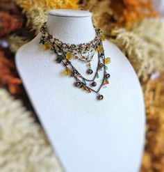 Fun and fabulous and dripping with charm(s) this beaded/chain choker festoon bib statement necklace is a feast for the eyes and will be a delight to wear.  It has a boho chic vibe with its hand-beaded collar and copper chain swag bib design in gorgeous fall colors, featuring topaz, moss green, light citrine, and gunmetal colored beads used to weave the collar, and the copper chain swags hung with golden yellow lucite flower charms, olivine green lucite leaf charms, copper flower charms, topaz br Leaf Beads Necklace, Bib Design, Swag Design, Leaf Beads, Detailed Necklace, Beaded Collar, Copper Chain, Leaf Charms, Complementary Colors