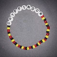 a beaded bracelet with the words grievendor written in white, yellow and red beads