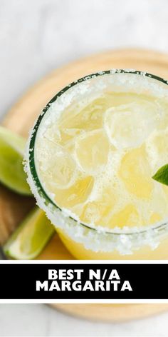 a margarita with limes and ice on a plate