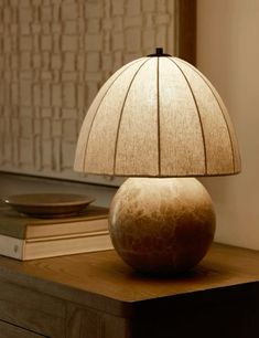 a lamp sitting on top of a wooden table next to a book and record player