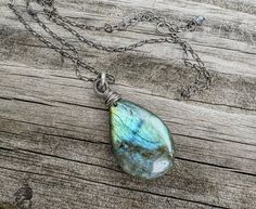 This necklace features a gorgeous polished natural labradorite cabochon, front-drilled and wire-wrapped in hand-oxidized sterling silver wire. The pendant suspends off an 18-inch hand-oxidized sterling silver long-and-short chain. The stone is shaped into a teardrop, with a slightly domed back and front. The gem has gorgeous green, blue, and yellow flash when light hits it. The polished gem measures approximately 1 wide and almost 1 1/2 inch long. Necklace finishes with a handmade hook and eye closure. Labradorite is considered the "magic stone", capable of increasing chances of serendipity for the wearer. It can also relieve stress, anxiety, and insomnia.  **Shipping** Your jewelry is ready to ship and will arrive in a natural cotton muslin gift bag. All orders ship in 1 business day. You Handmade Drop-shaped Labradorite Necklaces, Handmade Labradorite Drop Necklaces, Handmade Labradorite Drop Necklace, Wire Wrapped Labradorite Teardrop Pendant Necklace, Teardrop Labradorite Necklace, Labradorite Teardrop Beads For Jewelry Making, Wire Wrapped Labradorite Teardrop Jewelry, Labradorite Teardrop For Jewelry Making, Handmade Labradorite Drop Jewelry