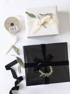 a black gift box with a ribbon and some other items