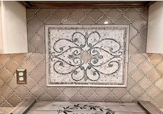 a tile backsplash in a kitchen with an ornate design on the back splash