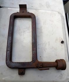 an old rusted metal handle on the side of a toilet