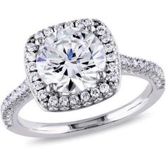 a cushion cut diamond surrounded by round diamonds in a halo setting with pave set shoulders