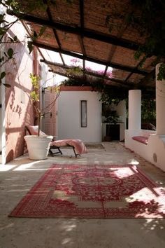 an outdoor area with rugs and potted plants