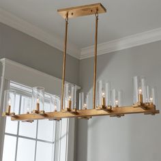 a chandelier with candles hanging from it's sides in front of a window