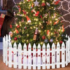 a small christmas tree in front of a white picket fence