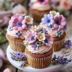 cupcakes with frosting and flowers on a plate