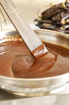 a wooden spoon stirring chocolate in a pan