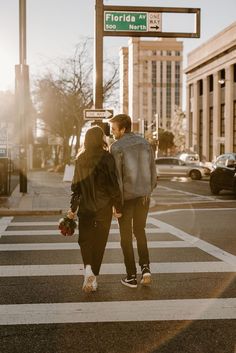 a man and woman are walking across the street