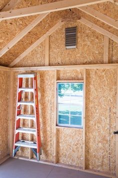 a ladder is in the corner of a room that has been framed with plywood