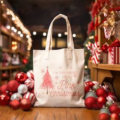 a white bag sitting on top of a wooden table next to christmas balls and ornaments