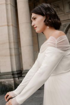 Simple, elegant, and a little bit different—this off-shoulder wedding dress with long tulle-draped sleeves is perfect for a modern courthouse ceremony. The soft illusion neckline gives it a romantic feel, while the sleek design keeps things understated and chic. For the bride who wants just a hint of drama without the fuss. #CourthouseWeddingDress #OffShoulderElegance #SimpleLongSleeves #EffortlessBride #SeniDey Courthouse Ceremony, Courthouse Wedding Dress, Informal Wedding Dresses, Off Shoulder Wedding Dress, Draped Sleeves, Wedding After Party, Off Shoulder Gown, Tulle Sleeves, Drape Sleeves