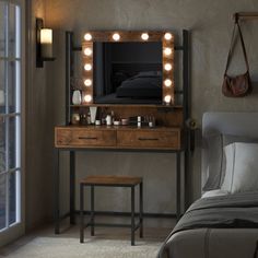 a bedroom scene with focus on the dressing table and lighted vanity mirror that is open