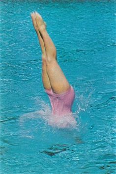 a woman in a pink bathing suit is floating in the water with her feet up