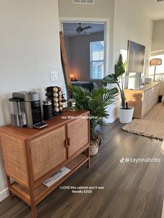 a living room filled with furniture and a coffee maker on top of a wooden cabinet