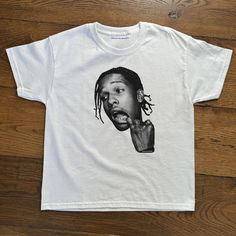 ASAP Rocky Graphic Baby Tee/T-shirt

Our tees are mid-weight 100% cotton with a classic 90's baby tee fit.
Shipping: Currently we ship worldwide from the following distribution hubs: UK, USA, Germany, Canada, Poland and Australia. White Unisex T-shirt With Character Print, Unisex White T-shirt With Character Print, Custom Print Graphic Tee For Streetwear