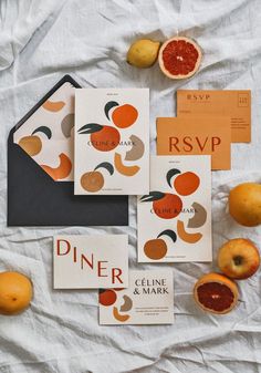 the stationery is laid out neatly on top of the table with oranges and lemons