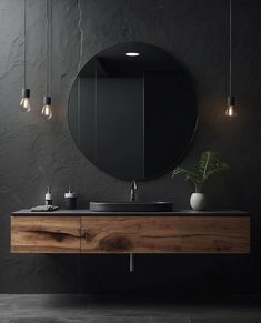 a bathroom with a sink, mirror and lights hanging from the ceiling in front of it