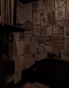 a room with many drawings on the wall and shelves full of books, papers, and other items