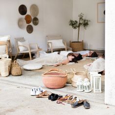 two women laying on the floor in front of baskets, shoes and other items that are scattered around