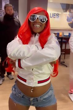 a woman with red hair and sunglasses is standing in front of other people wearing white jackets