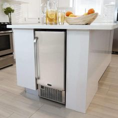 a stainless steel dishwasher sitting on top of a white counter in a kitchen