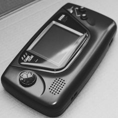 a black and white photo of a cell phone on a table with the screen turned off