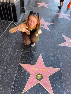 a woman kneeling down in front of a star on the hollywood walk of fame