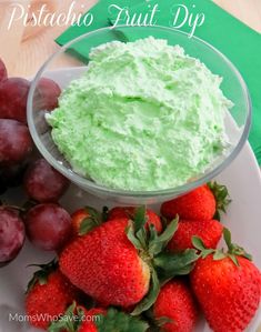 some strawberries and grapes on a white plate with green dip in the middle that says, pistachio fruit dip