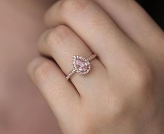 a woman's hand with a pink diamond ring