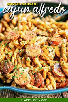 pasta with sausage and tomatoes in a blue bowl on a wooden table, ready to be eaten