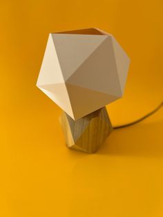 an origami lamp sitting on top of a yellow table