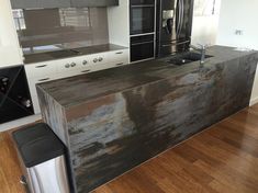 a kitchen with an island in the middle of it and stainless steel appliances on the wall