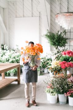 a man holding a vase filled with orange flowers