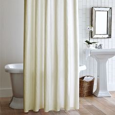 a bath room with a sink and a shower curtain next to a white tub in front of a mirror