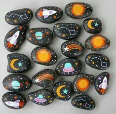 painted rocks with rockets, planets and stars are arranged in the shape of a circle