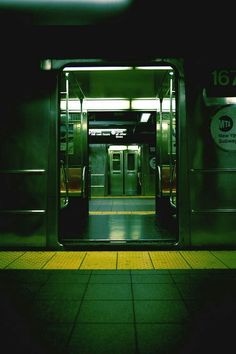 an empty subway car with its doors open at night time, and the floor is tiled